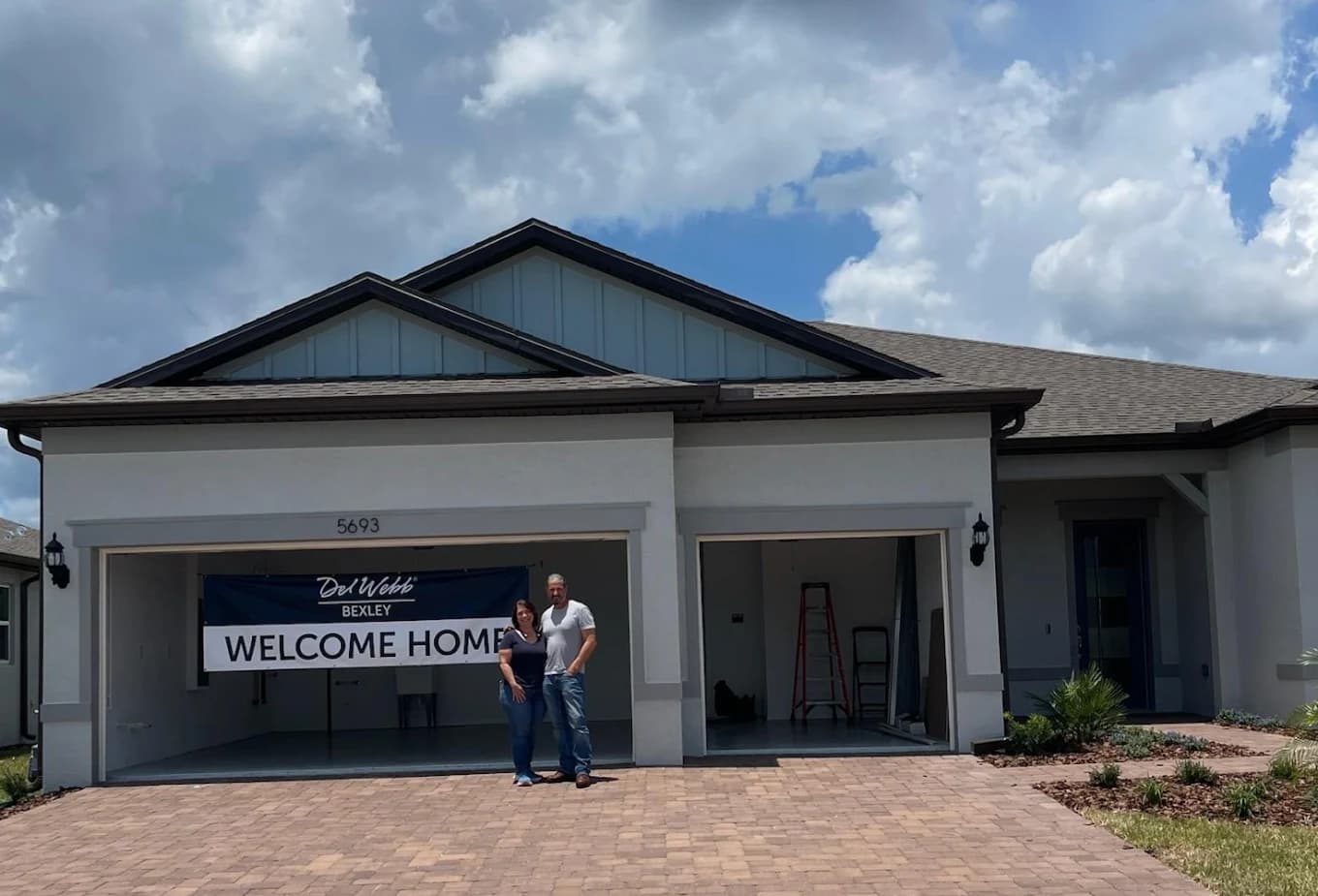 Couple standing in front of their new home on move-in day